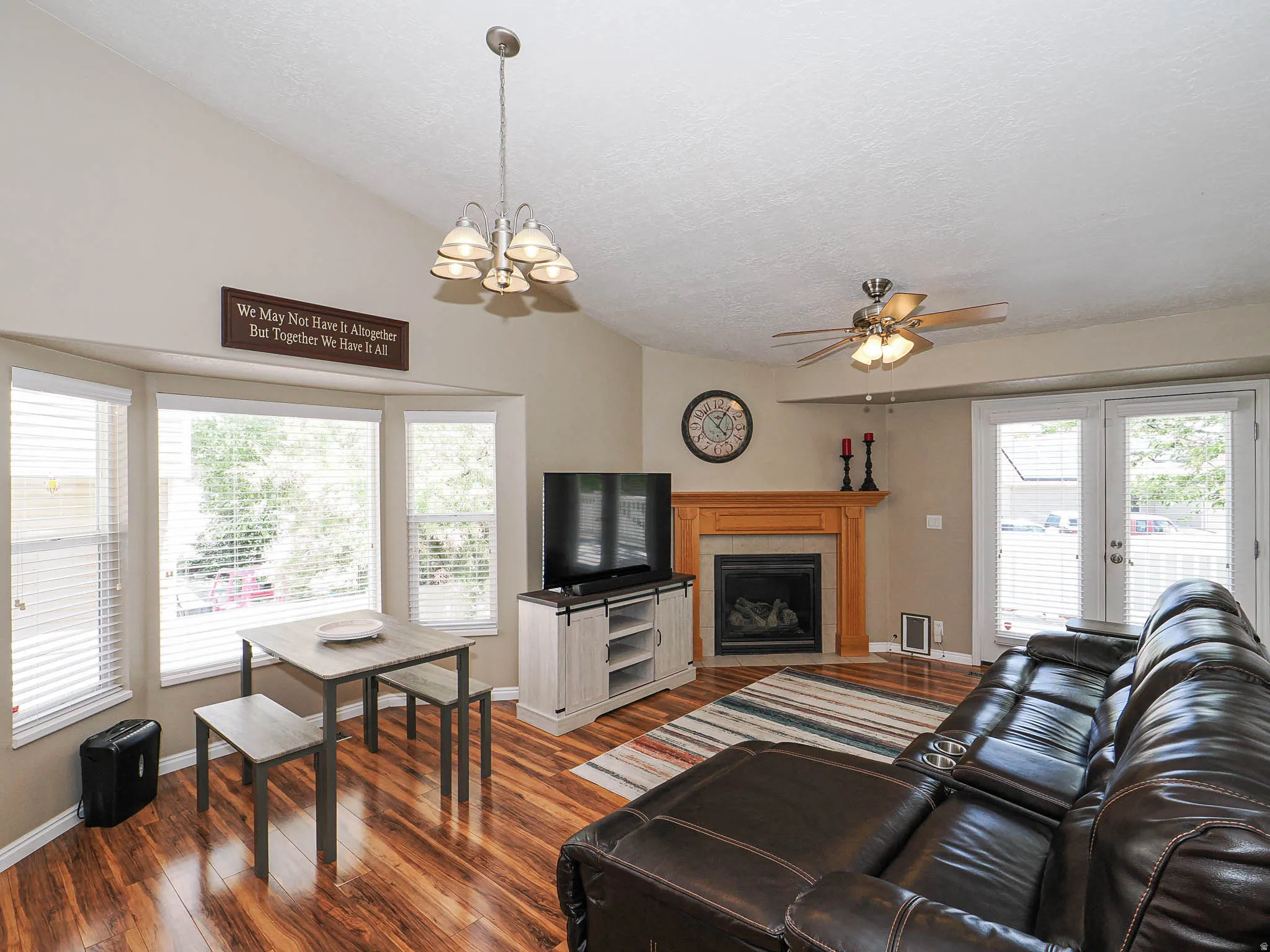 Spacious living area featuring wood-finish flooring, a fireplace with a wood mantle, and double French doors