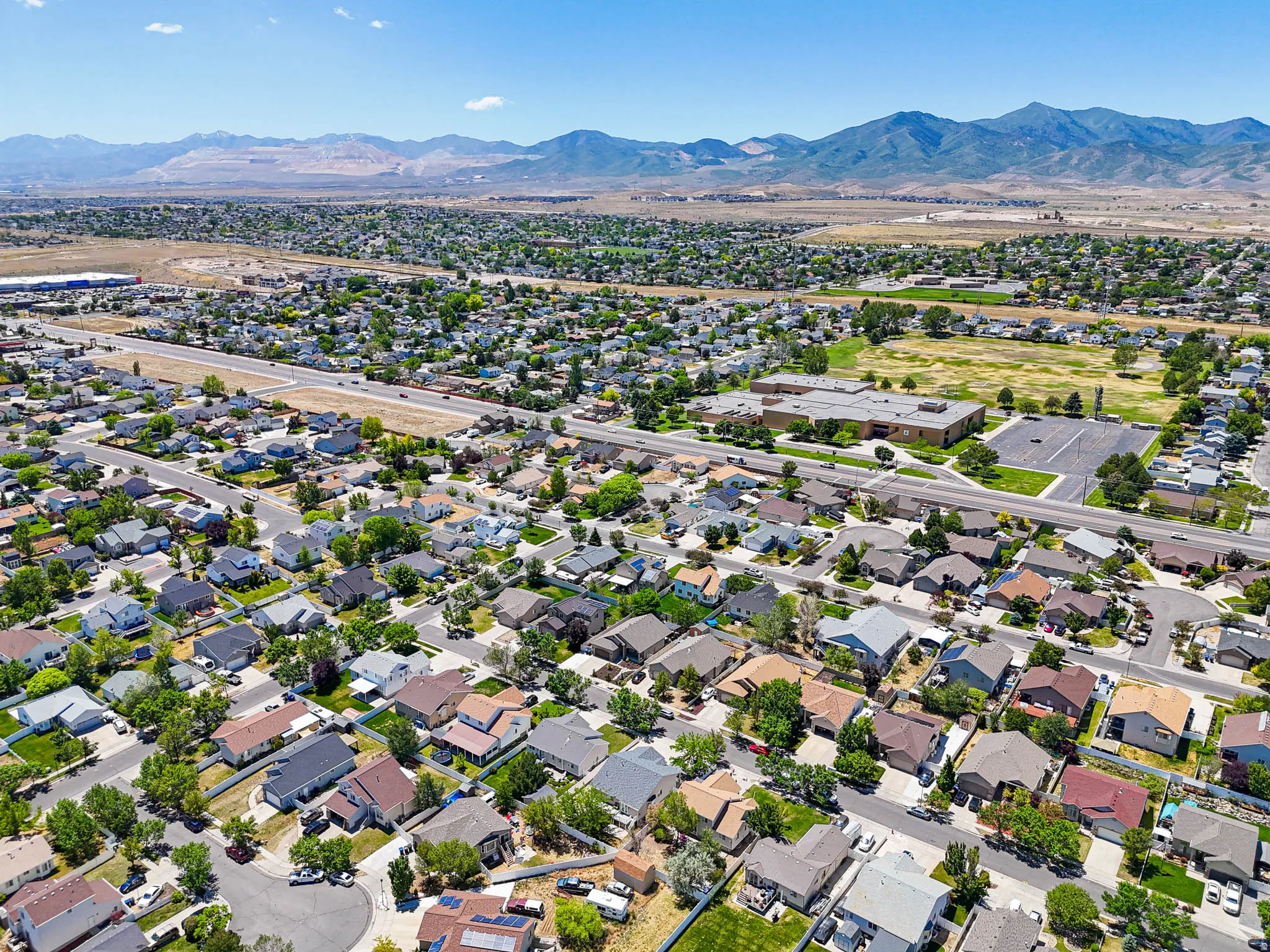Aerial perspective showcasing a residential neighborhood with a distant mountain range backdrop