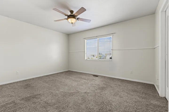 Spacious room featuring neutral carpeting and light-colored walls