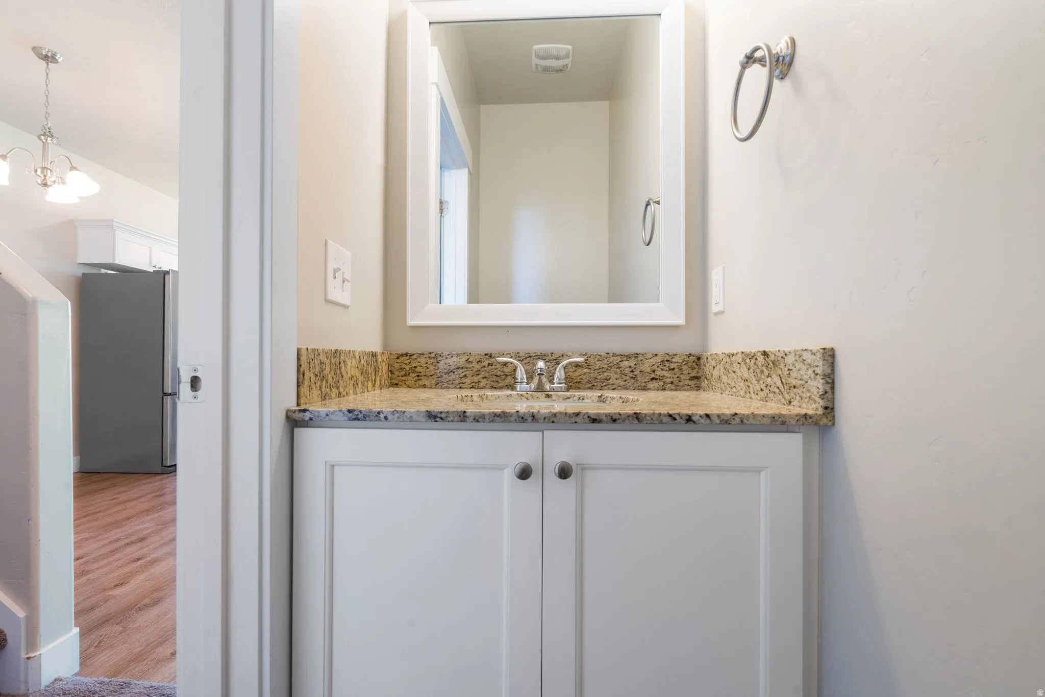 Half-bathroom featuring a white vanity with a granite-adult height-countertop