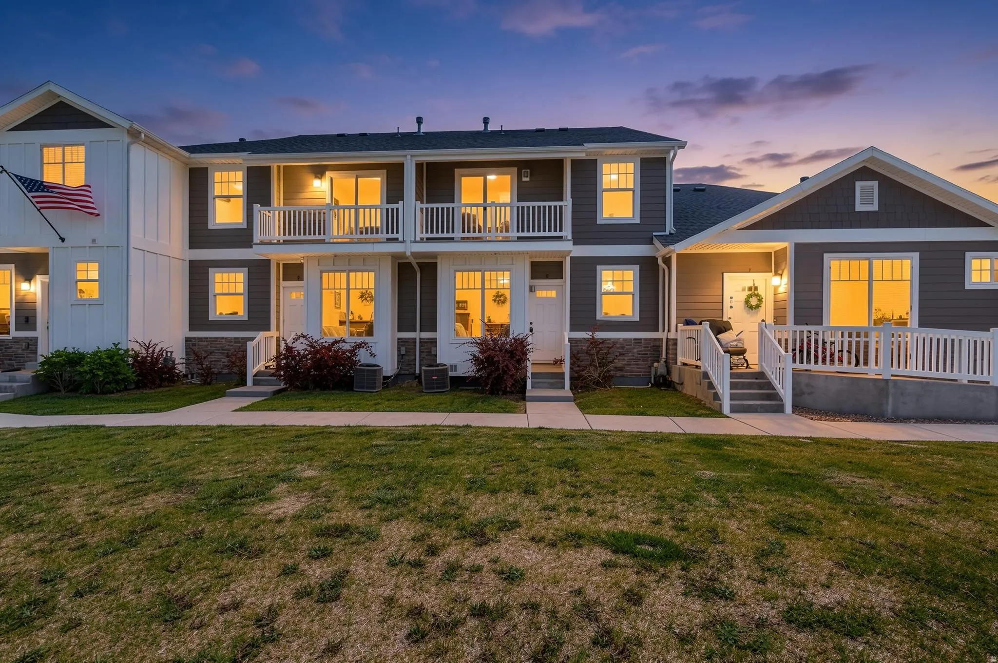 Townhome exterior featuring neutral siding and white trim accents & balcony