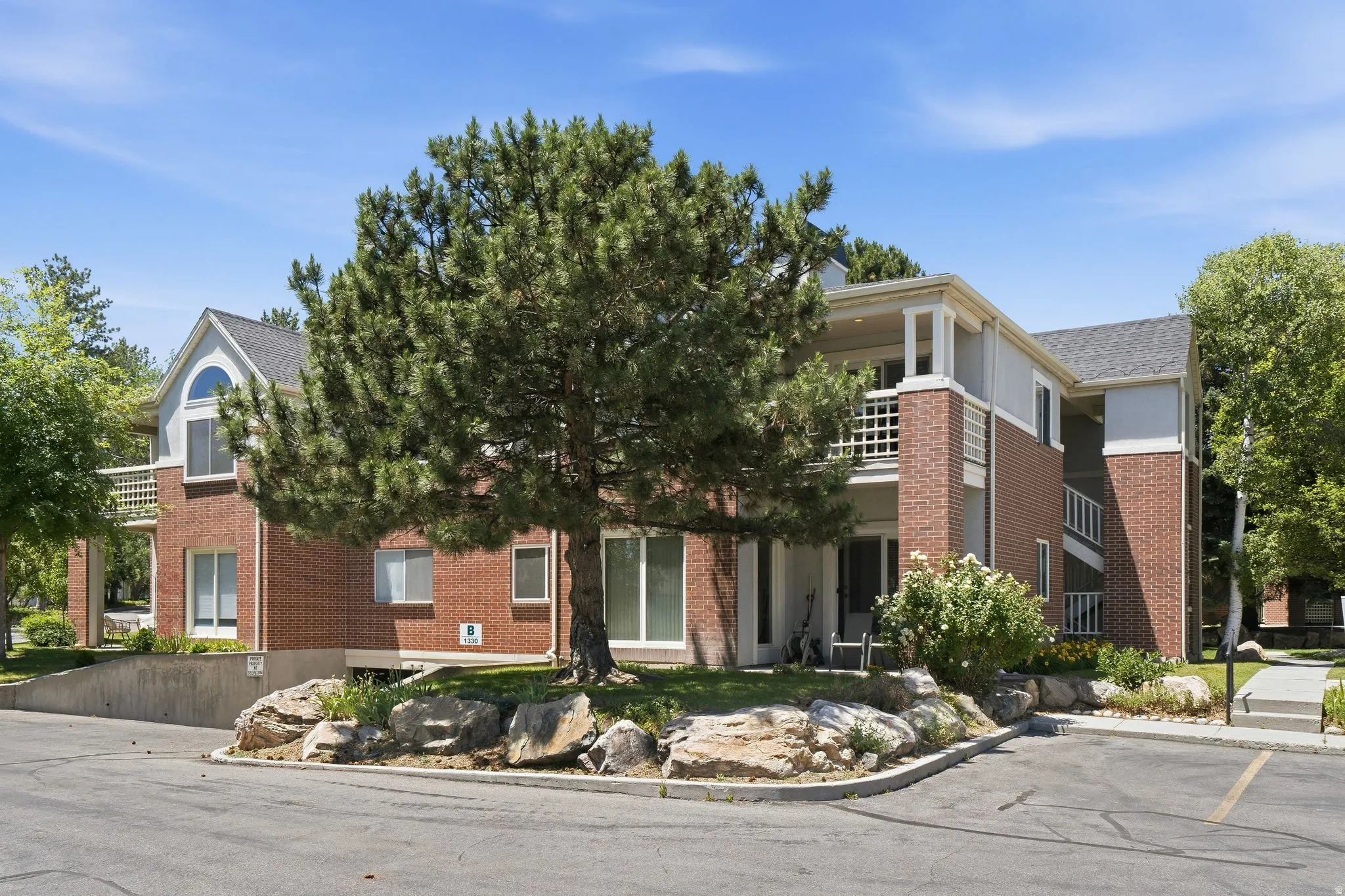 Brick exterior multi-story building featuring a prominent arched window and multiple balconies