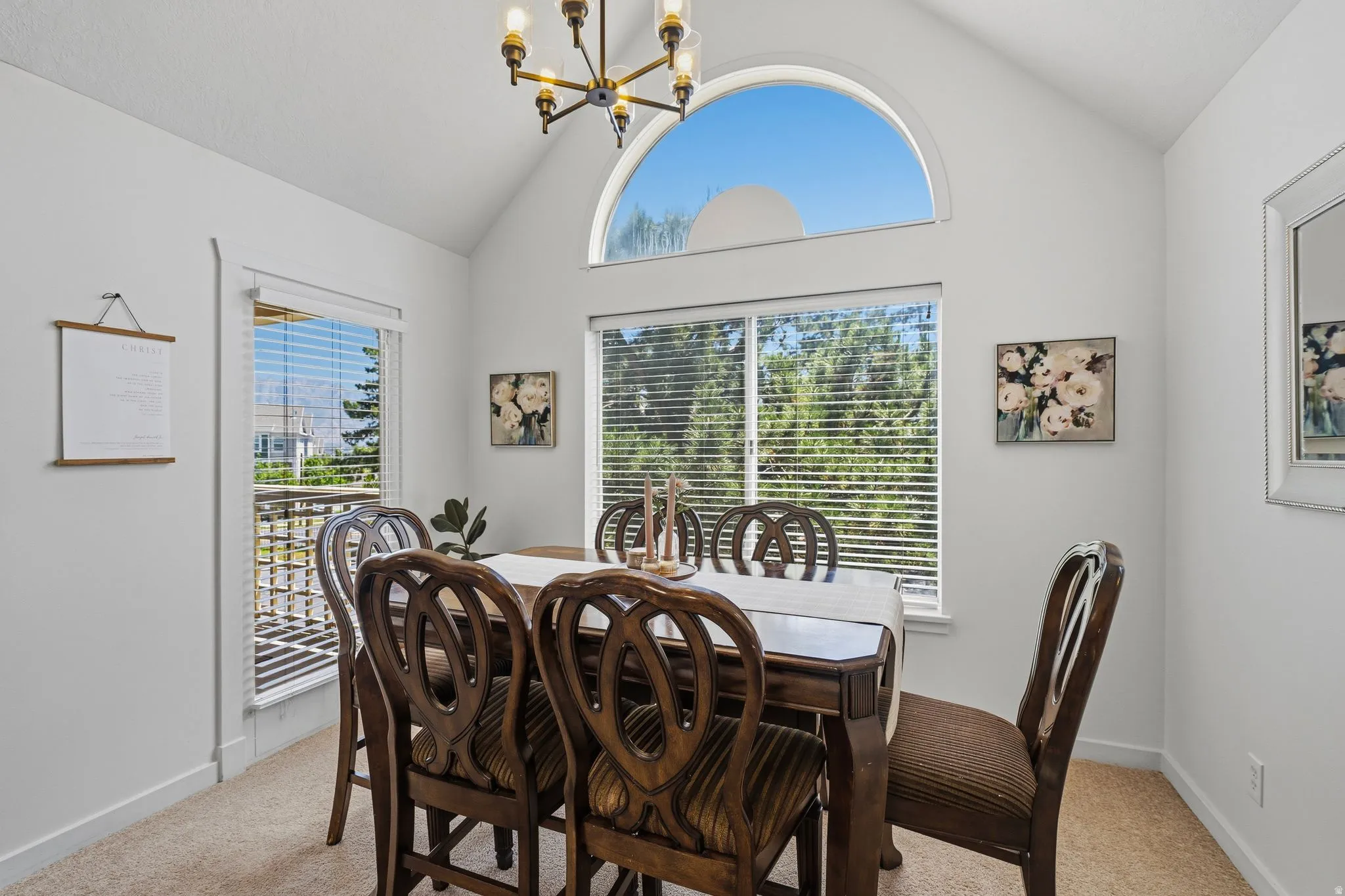 Vaulted ceiling dining area featuring chandelier