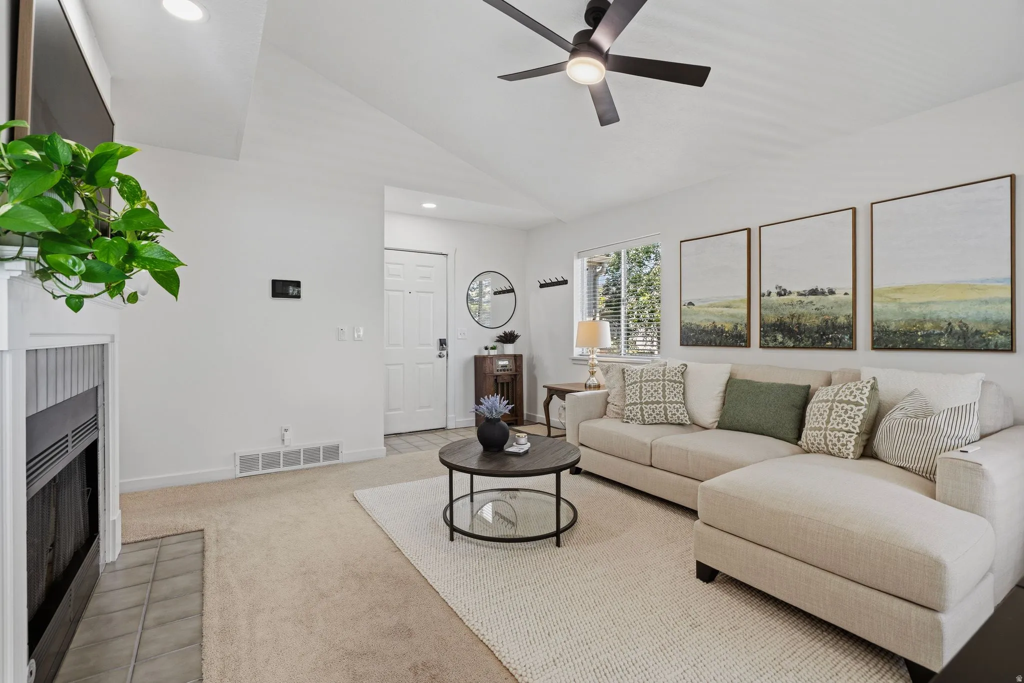 Living area featuring a vaulted ceiling and a ceiling fan