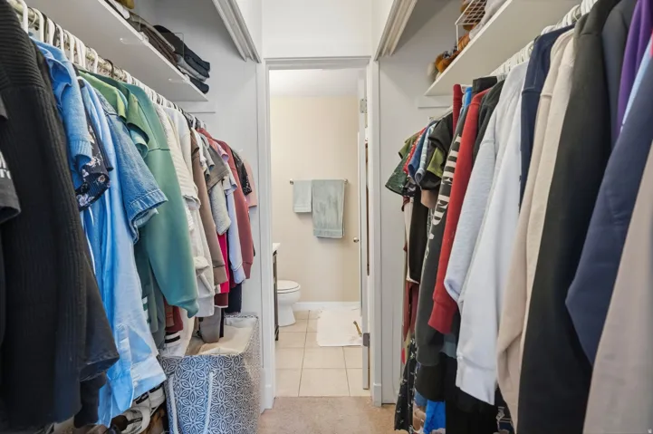Walk-in closet featuring dual shelving and hanging rods located in primary bedroom