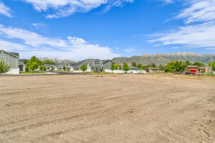 Expansive vacant lot featuring a cleared, level building area with a mountain backdrop