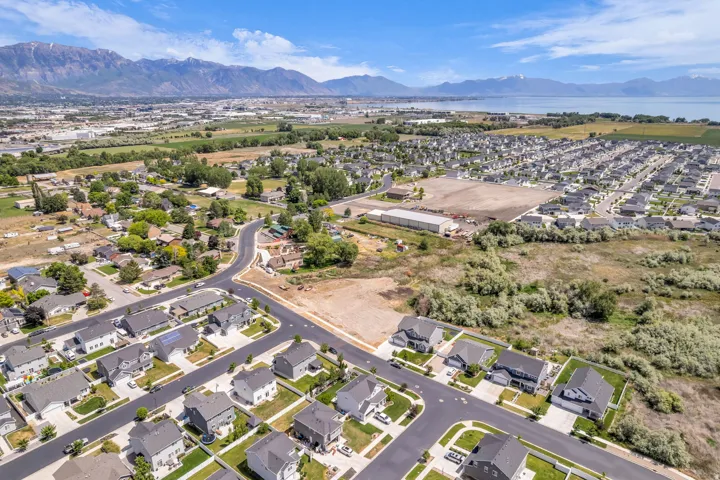 Aerial view of a residential community featuring established homes, new construction, and undeveloped land