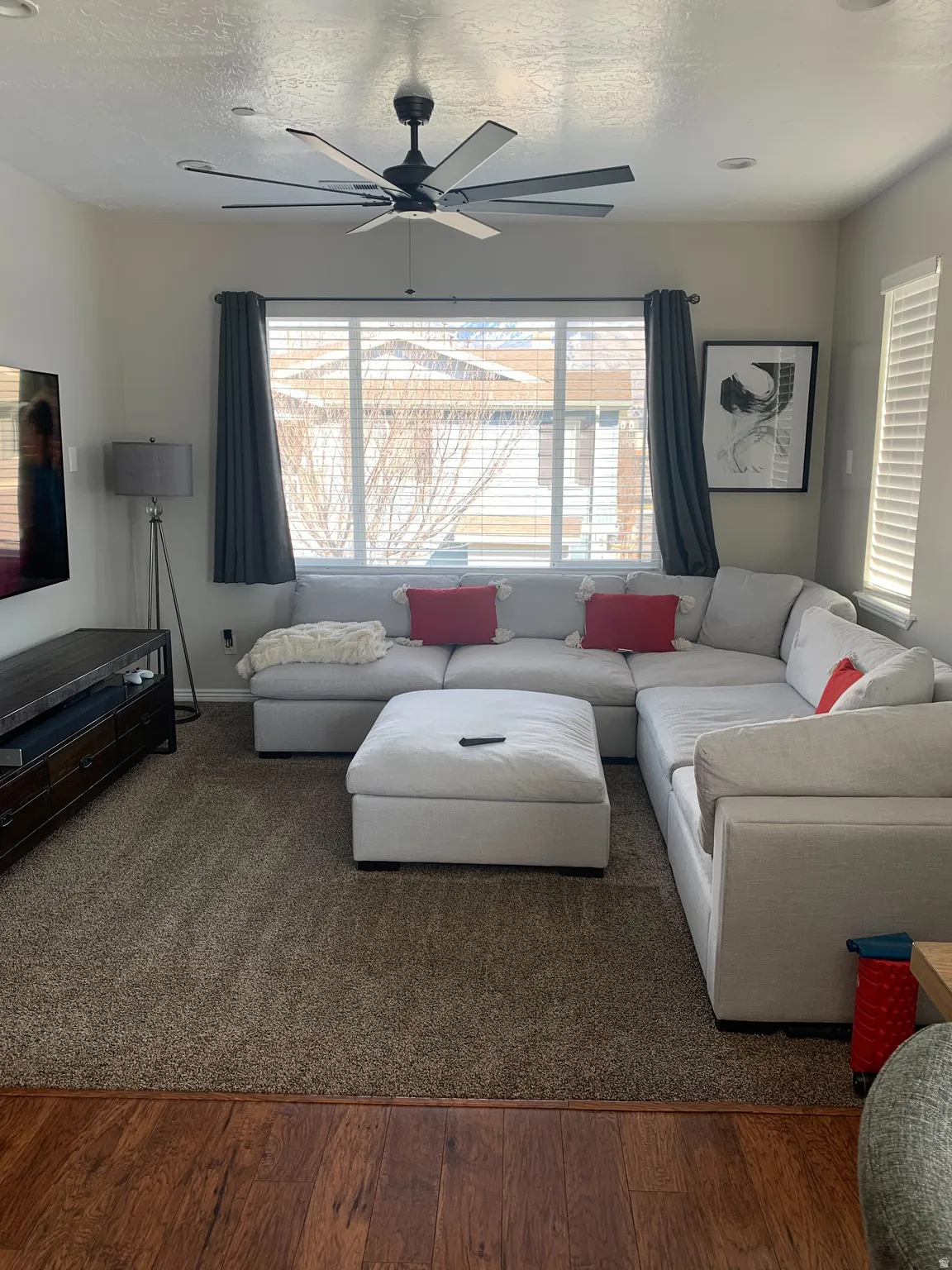 Open-concept living space with a multi-blade ceiling fan and recessed lighting
