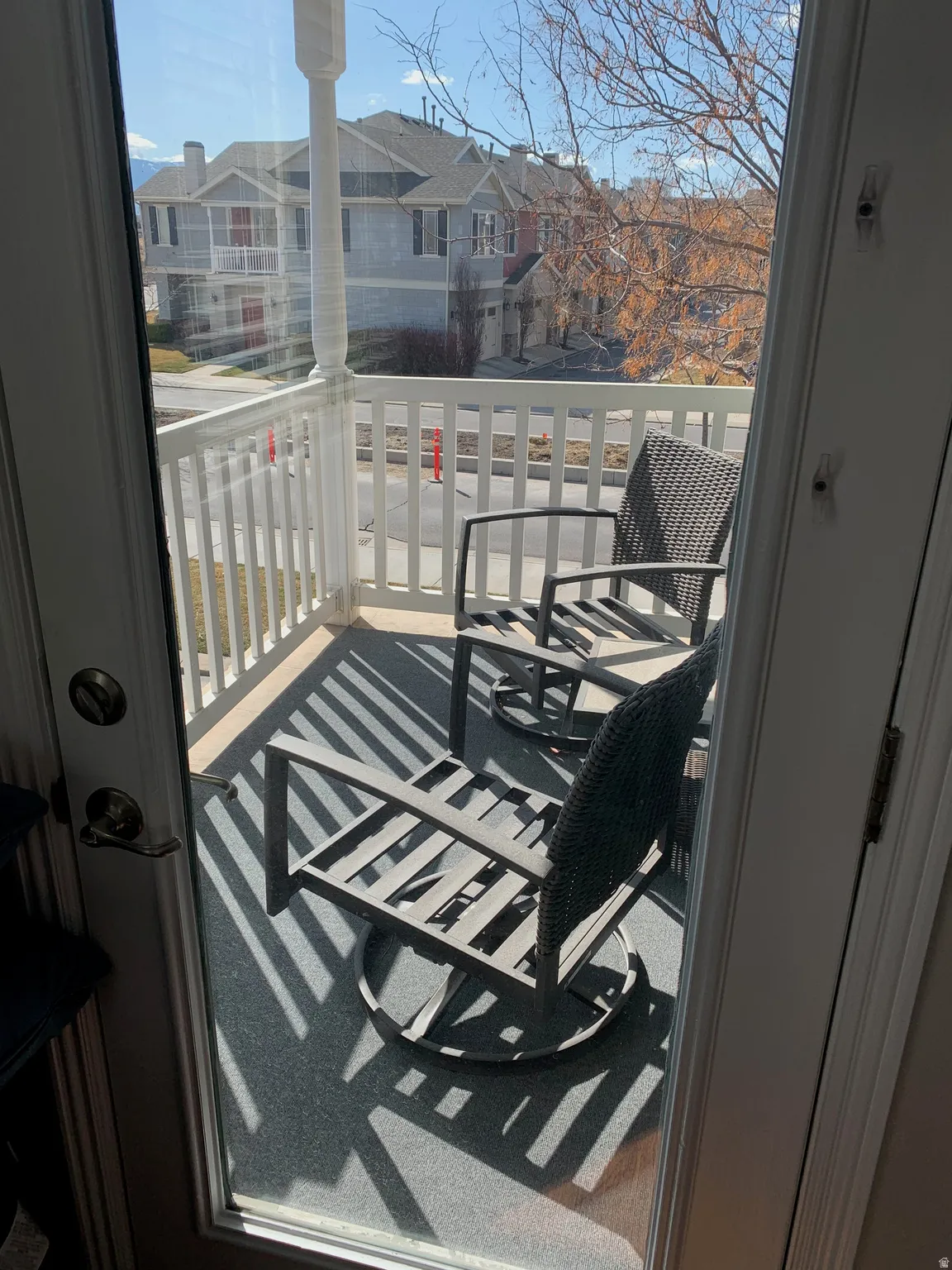 Outdoor balcony featuring a white railing and gray outdoor carpeting