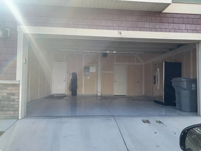 Two-car garage with unfinished walls, a concrete floor, and two interior access doors