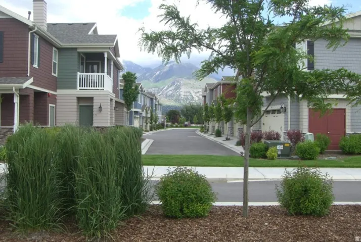 Residential street featuring townhome-style residences with covered entries and balconies