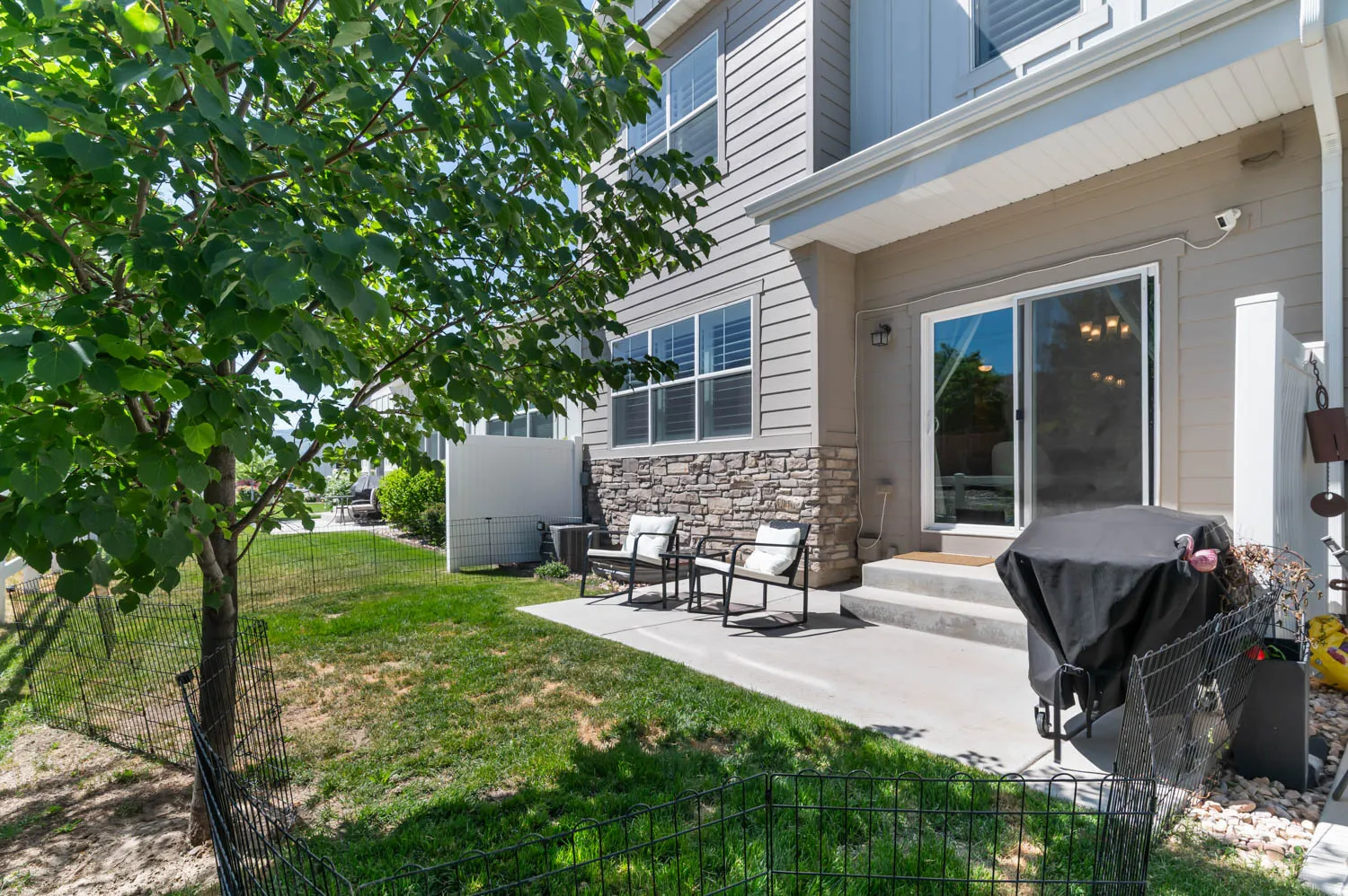 Private patio with direct access to the interior, featuring a sliding glass door and stone facade detailing