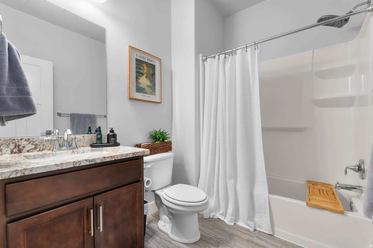 Bathroom featuring a single vanity with stone-finish countertop, wood-finish cabinetry, and chrome fixtures