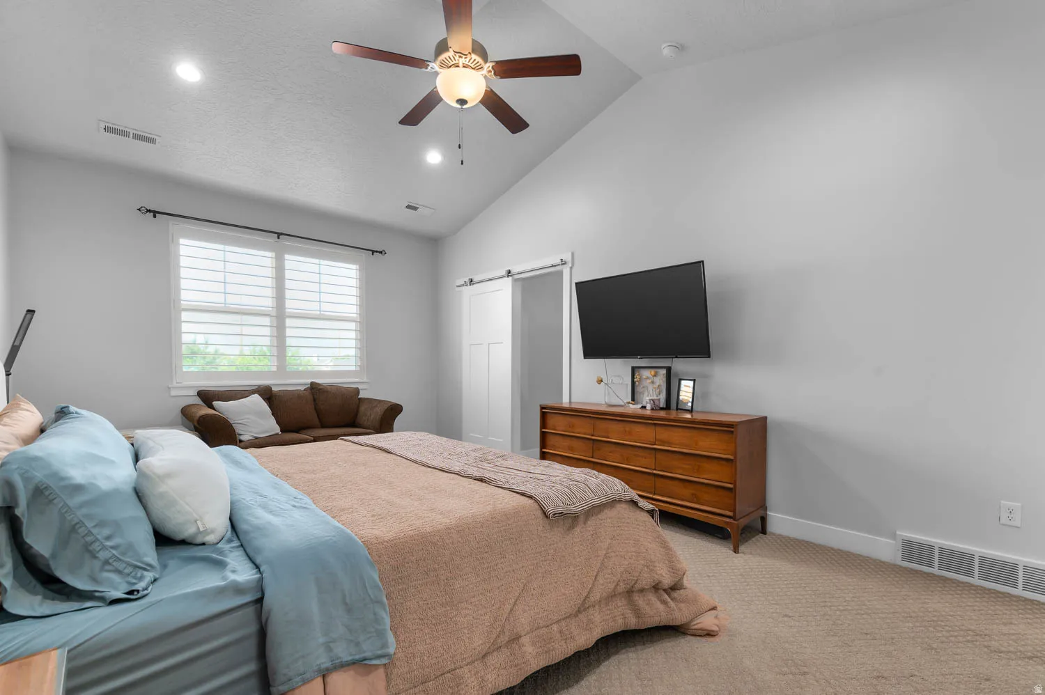 Vaulted ceiling featuring a ceiling fan, recessed lighting, and a double window with white plantation shutters