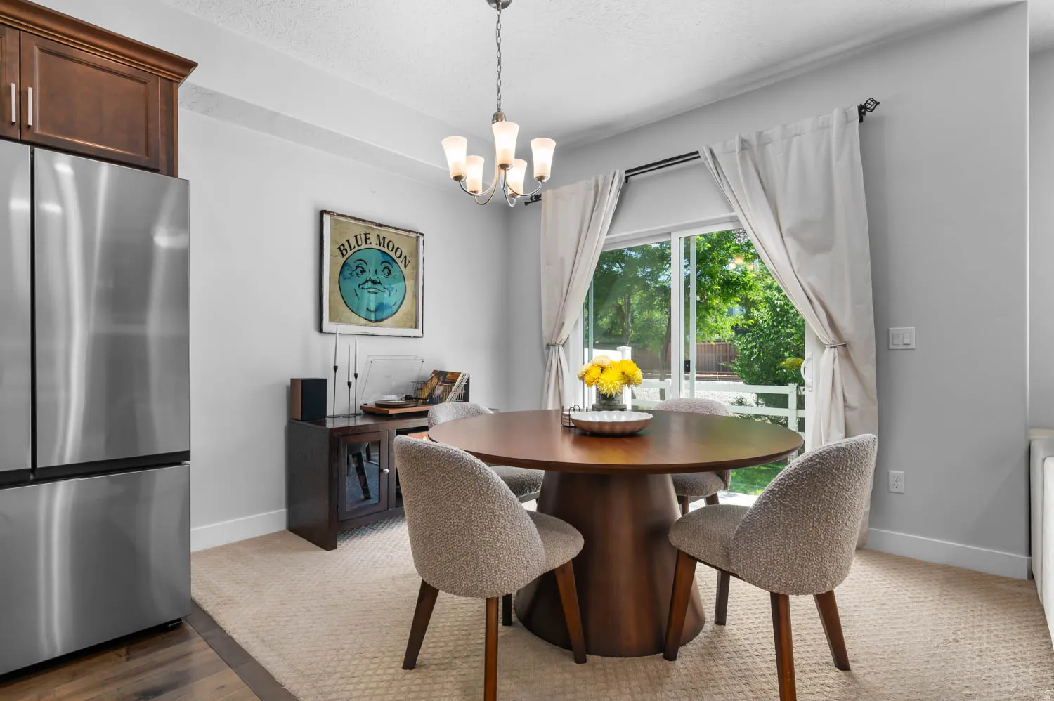 Dining area featuring a sliding glass door, a contemporary chandelier, and light-toned wall paint