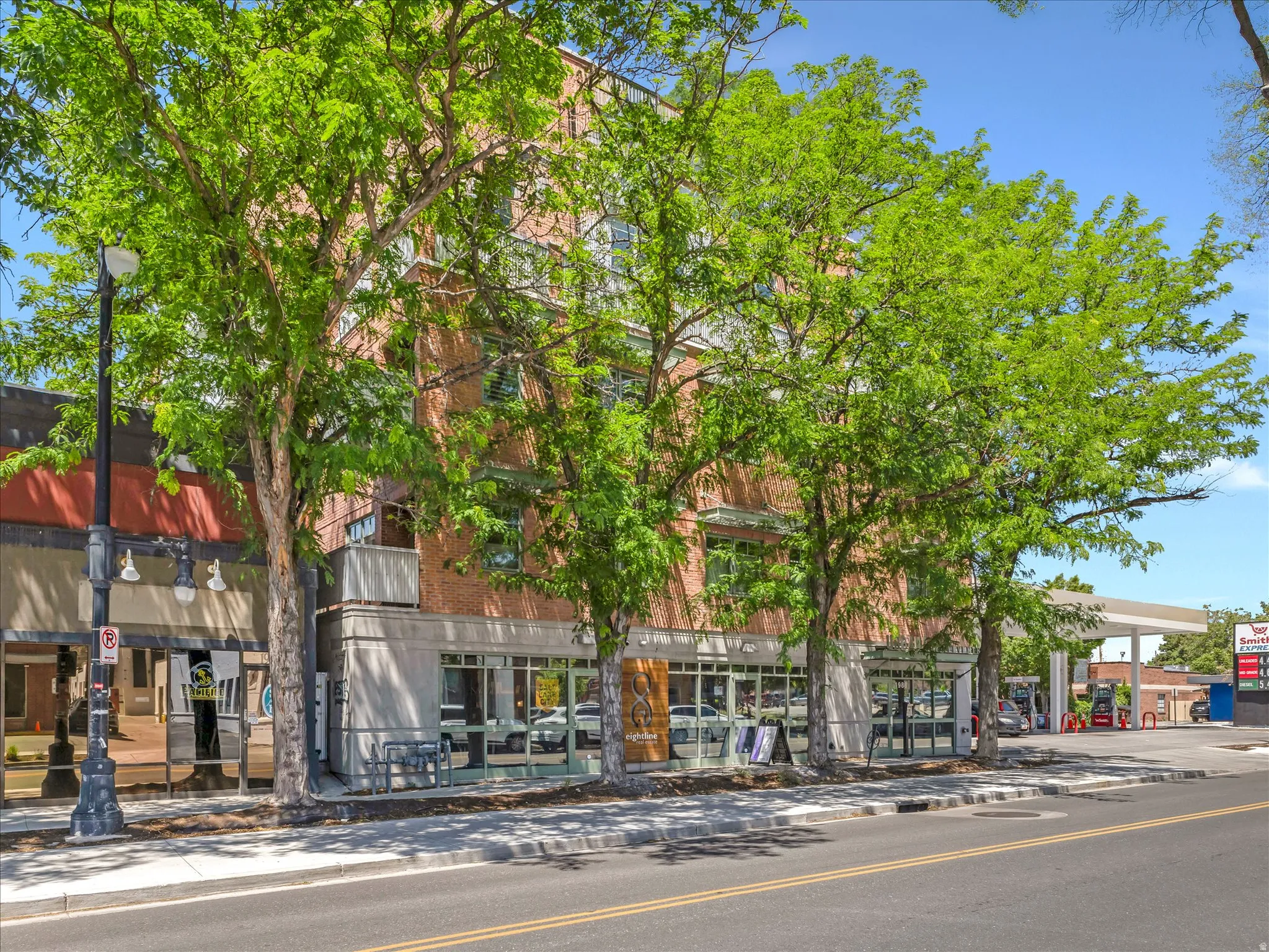 Multi-story brick building featuring ground-floor retail storefronts with large glass windows