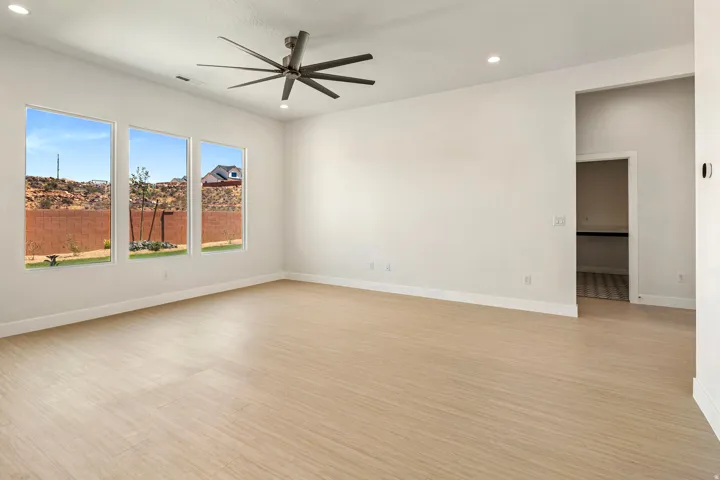 Spacious room featuring three tall windows offering natural light and desert landscape