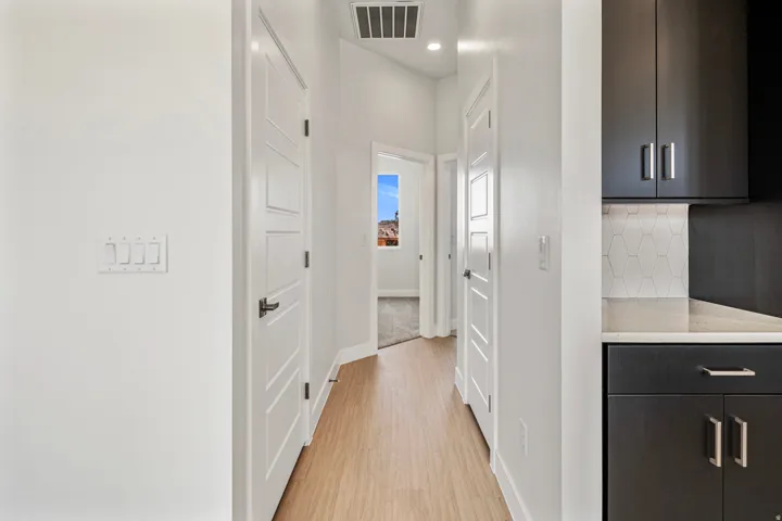 Hallway featuring wood-finish flooring and modern white doors