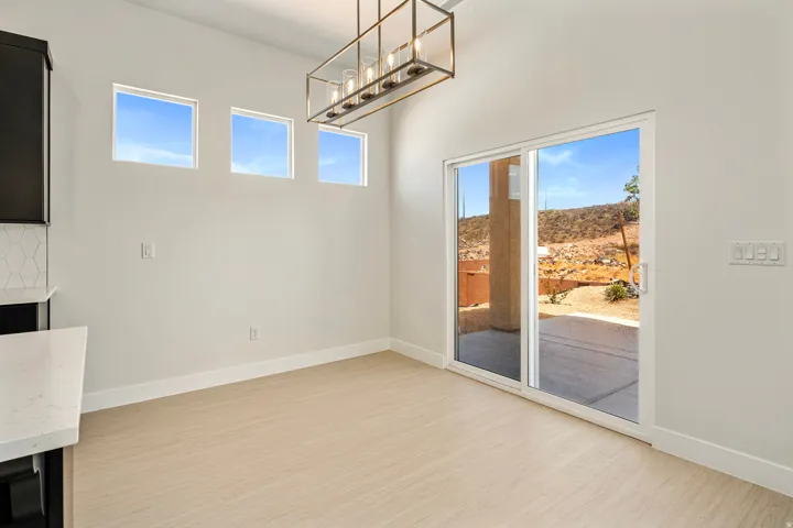Dining area featuring light wood-finish flooring and a contemporary linear chandelier