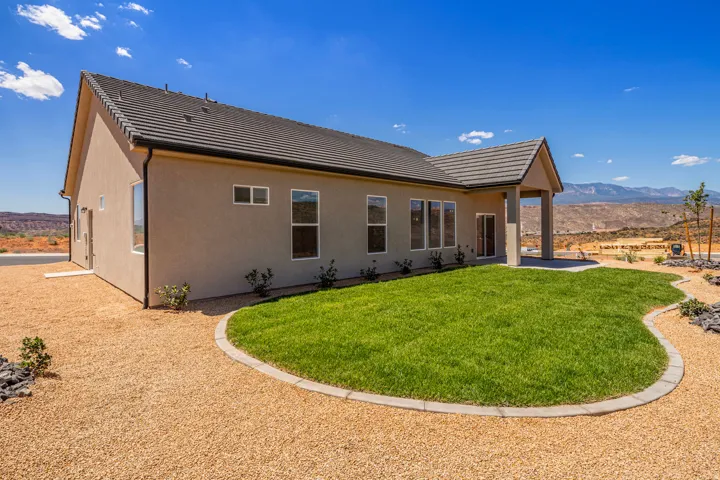 Rear exterior with a covered patio, stucco siding, and a tiled roof