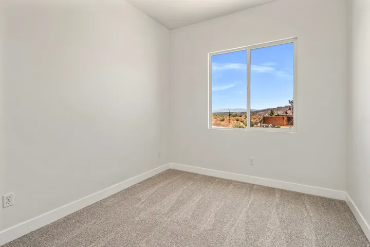 Bright interior room featuring a large window with white trim, offering expansive desert scenery