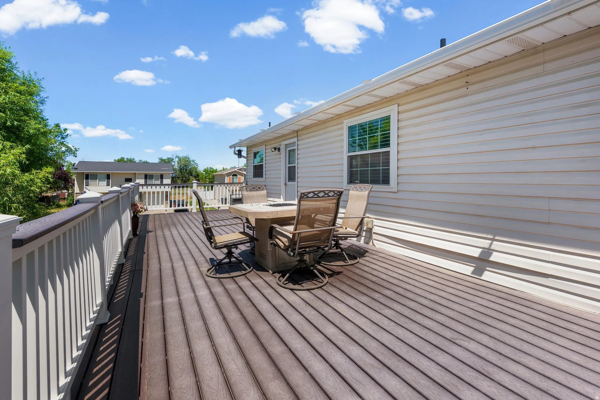 Expansive outdoor deck featuring composite decking and white railing, ideal for outdoor gatherings