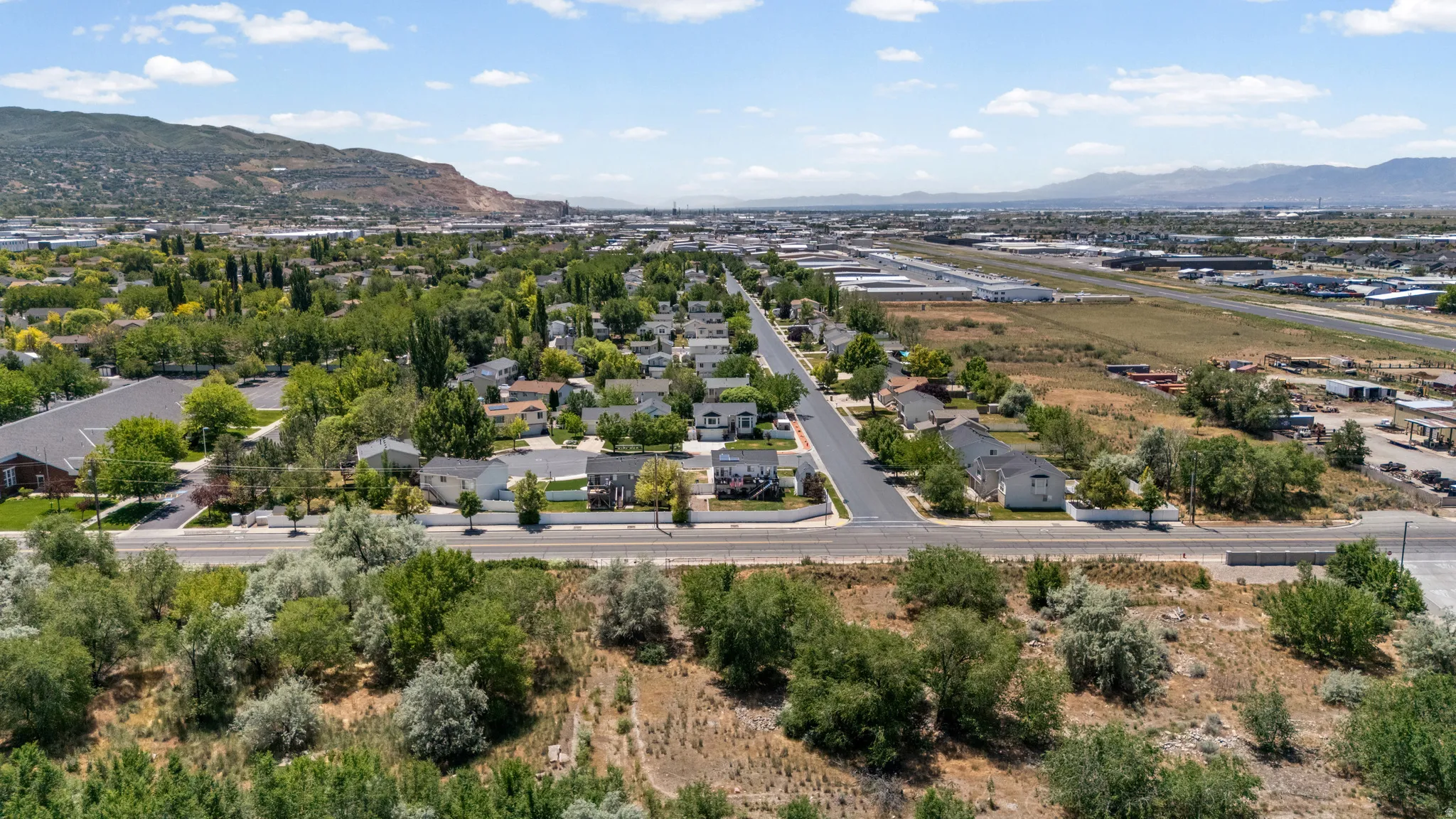 Expansive aerial perspective showcasing a residential neighborhood with established homes and mature trees