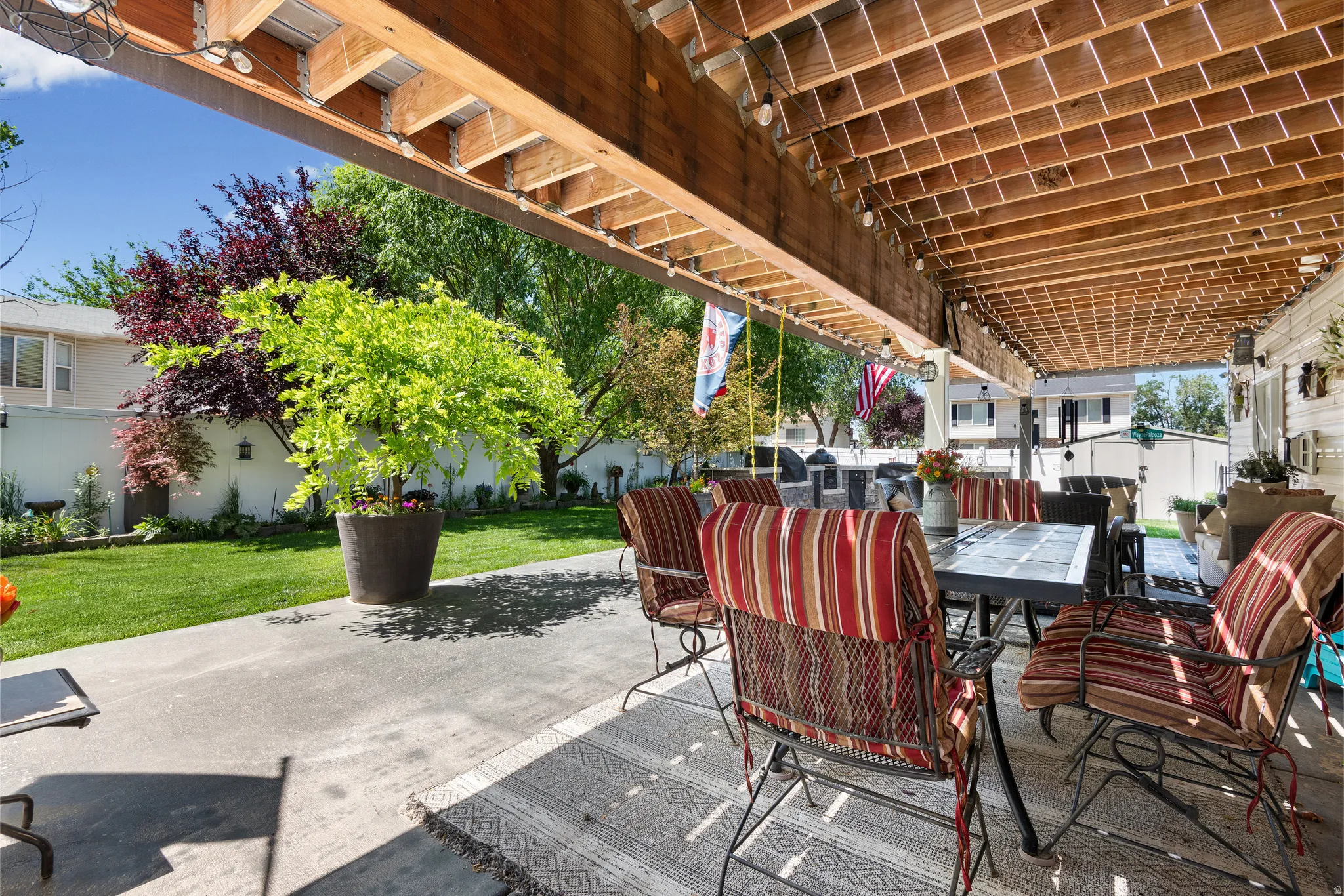 Covered patio featuring an exposed wood ceiling with integrated string lighting