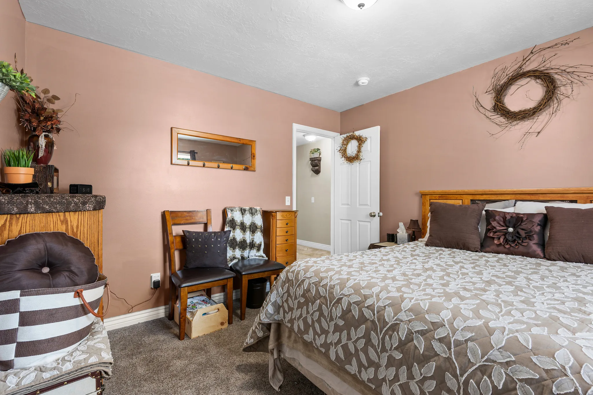 Carpeted bedroom with a wood headboard and warm-toned walls