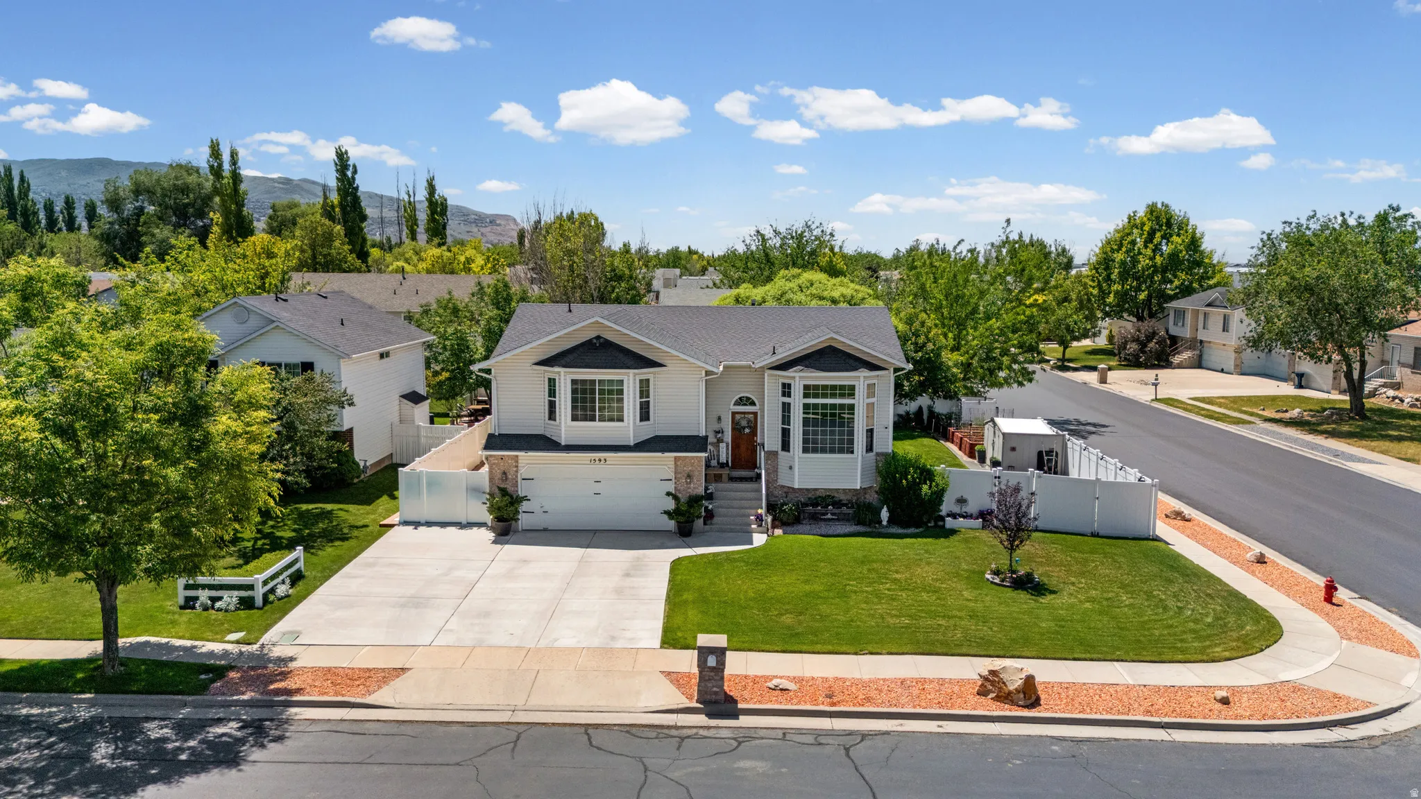 Two-story residence featuring a bay window, a dual-car garage, and a concrete driveway