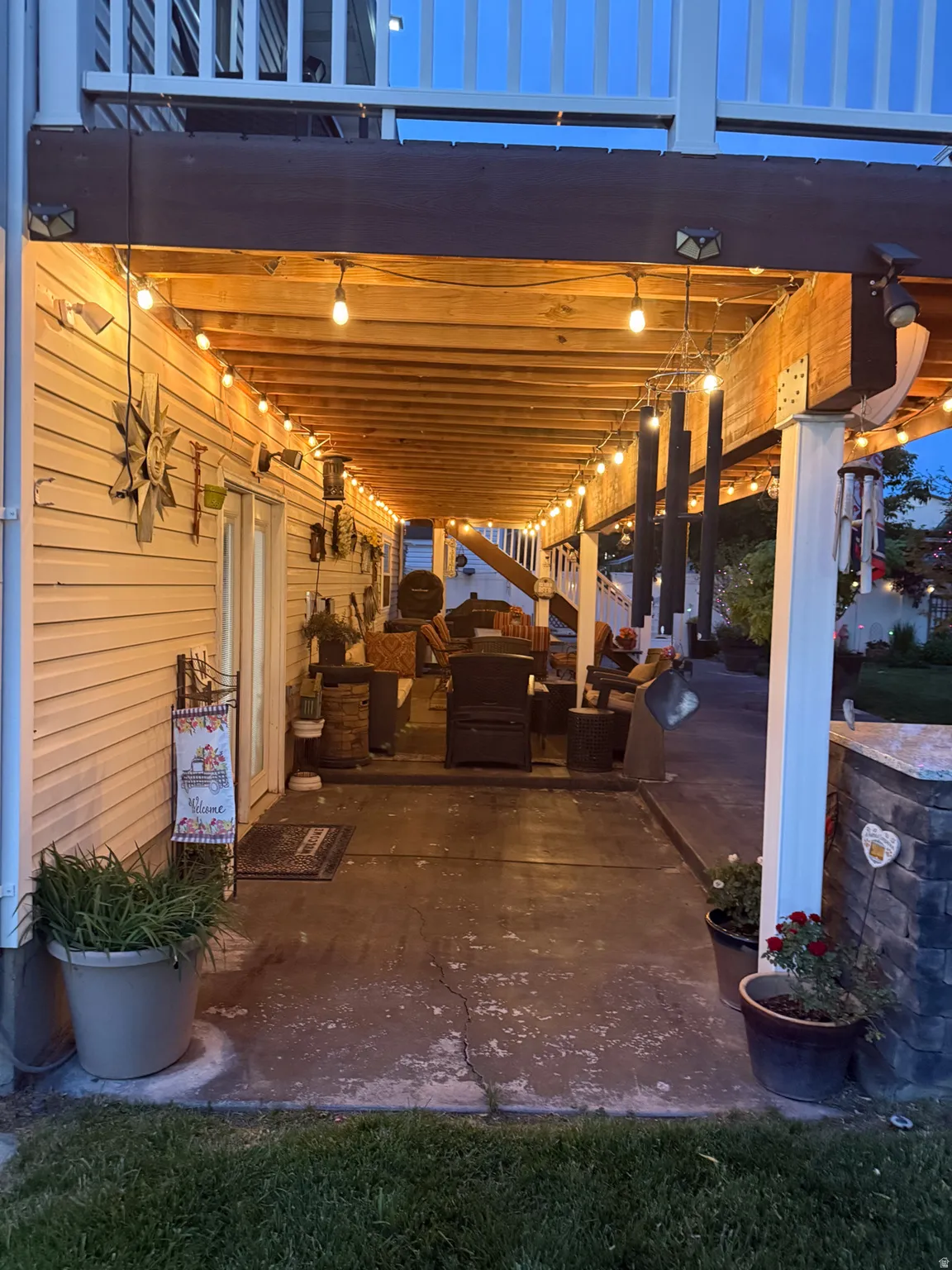 Covered outdoor living area with string lighting and concrete patio flooring