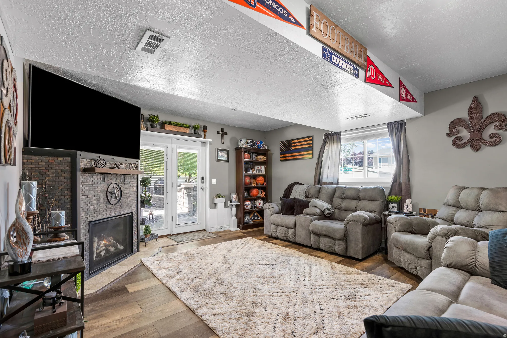 Living area featuring a contemporary fireplace with stone surround, wood mantel, and integrated entertainment space