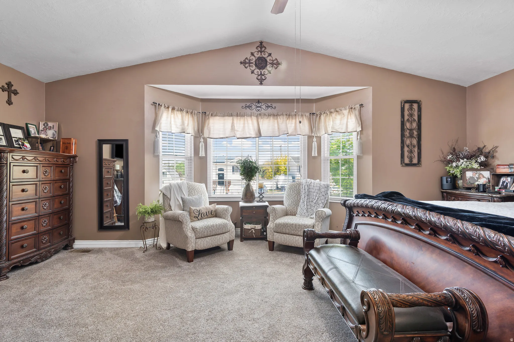 Spacious room featuring vaulted ceilings and a bay window with multiple panes