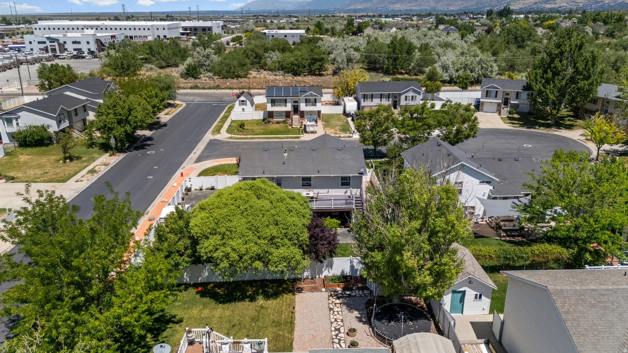 Expansive property featuring a multi-level deck, a detached shed, and mature perimeter trees