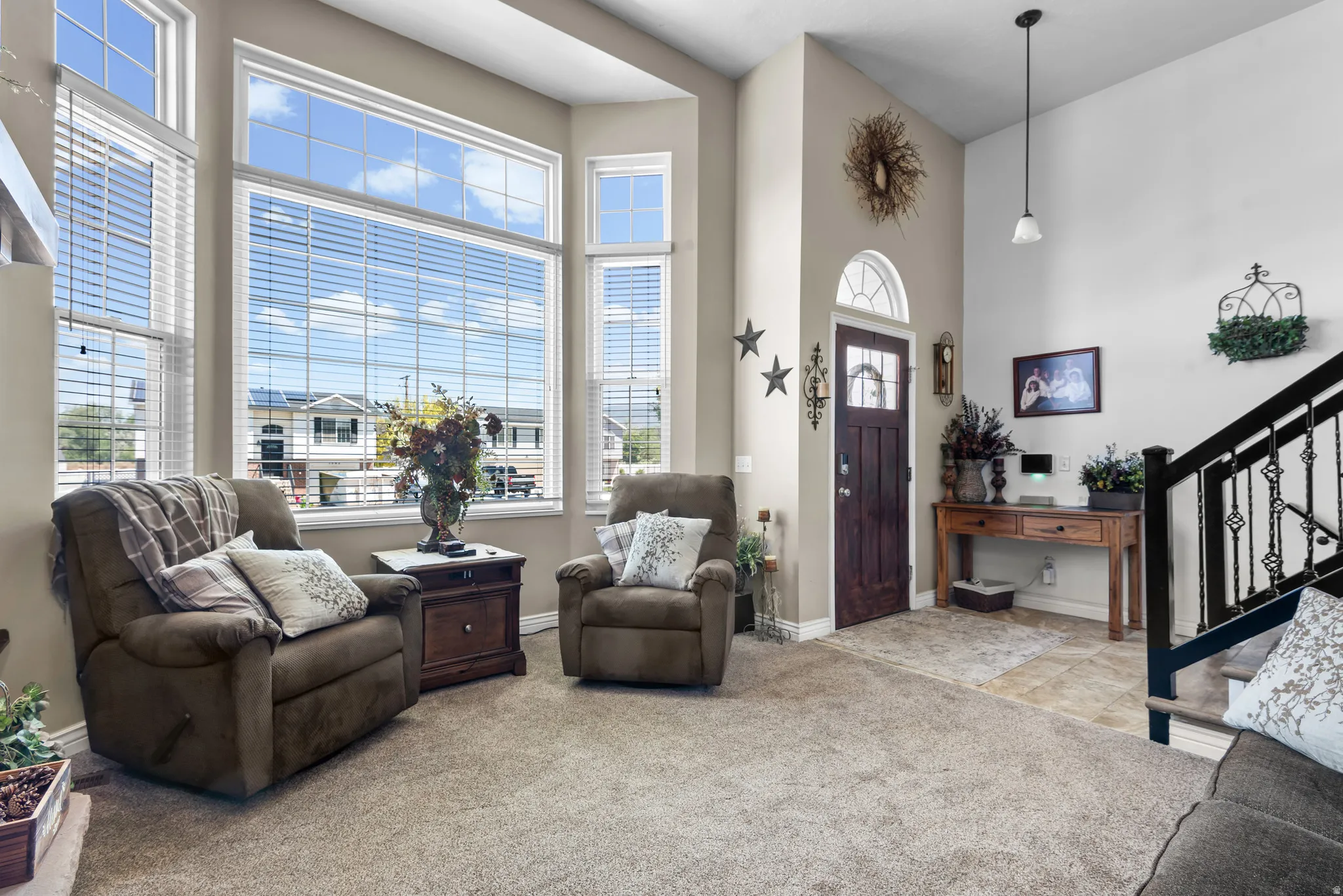 Vaulted entryway featuring a dark wood front door with an arched transom window