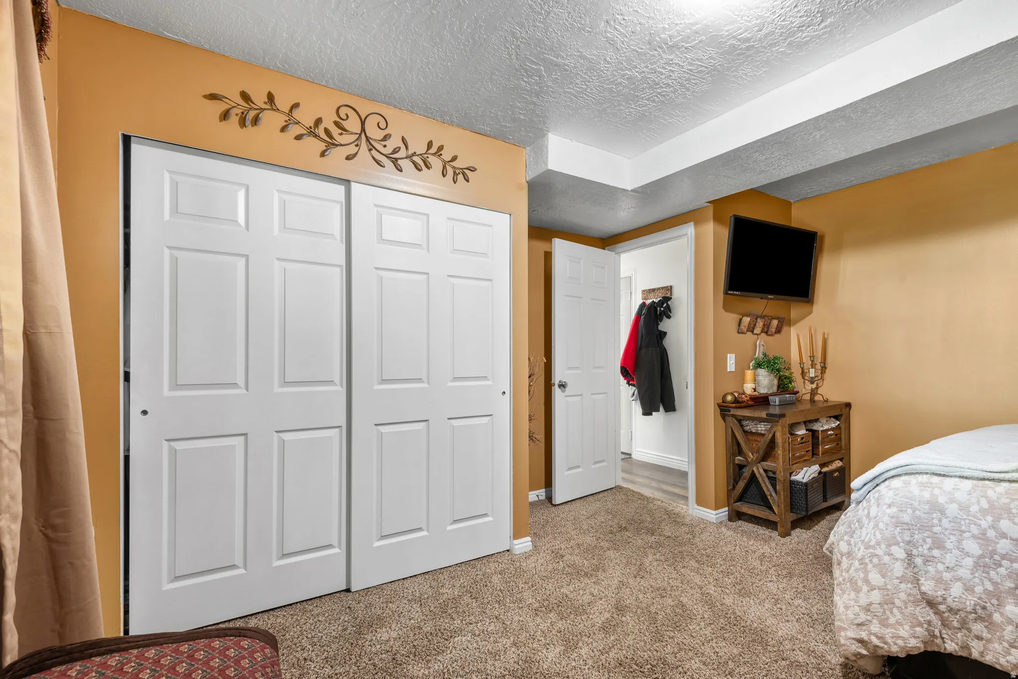 Bedroom featuring light brown carpeting and warm-toned walls