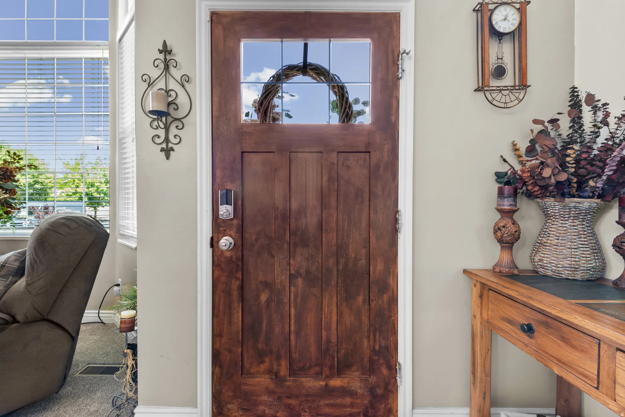 Rich wood-finish entry door with a frosted glass panel and smart lock system