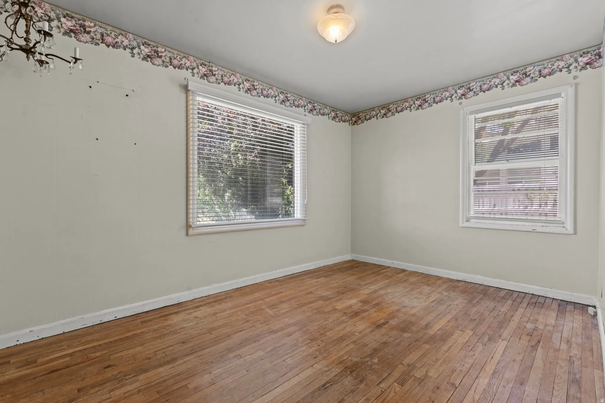 Wood-finish flooring throughout, complemented by two windows with horizontal blinds