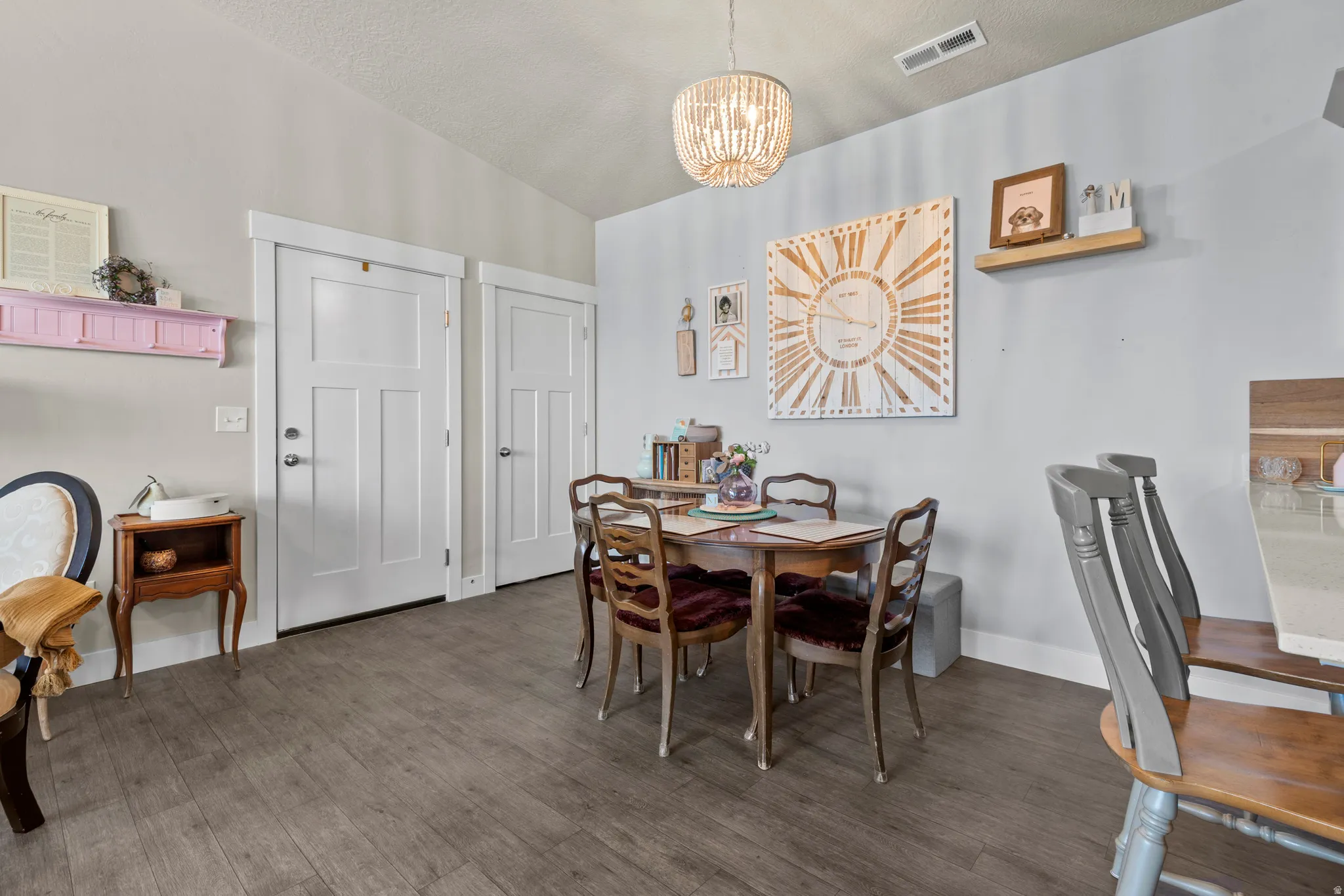Dining area featuring wood-finish flooring, a contemporary beaded chandelier, and light-toned walls