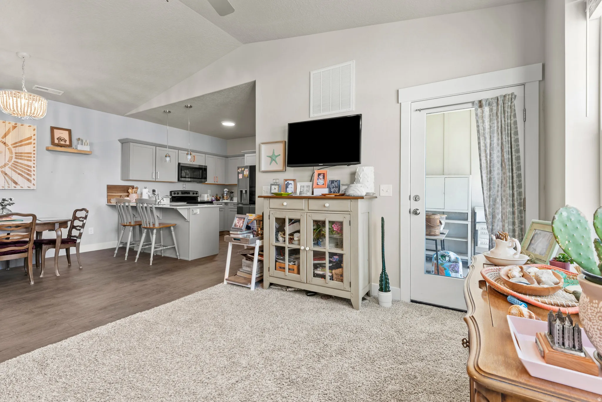 Open-concept living area featuring a vaulted ceiling and light gray walls