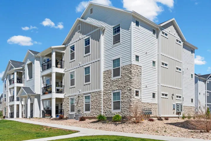 Multi-level residential building featuring a stone veneer foundation and horizontal siding