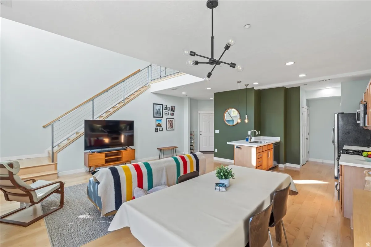 Open-concept living space featuring wood-finish flooring and a modern chandelier