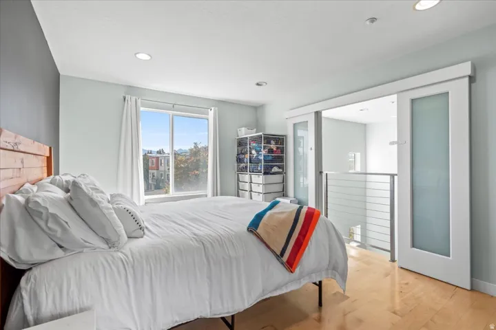 Hardwood-style flooring throughout this space with recessed lighting and a large window
