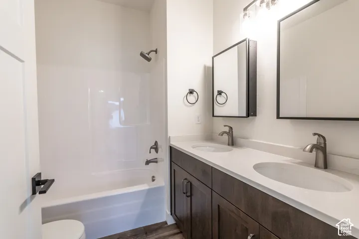 Dual vanity with undermount sinks, light-toned countertops, and dark wood-finish cabinetry