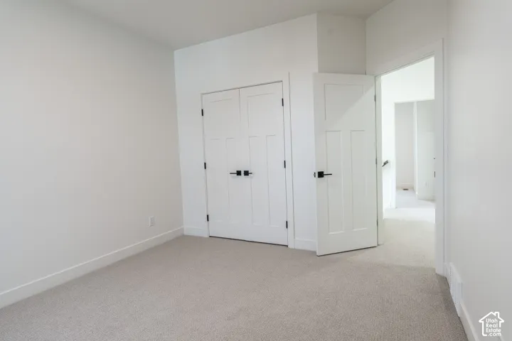 Neutral carpeting, white trim, and white walls