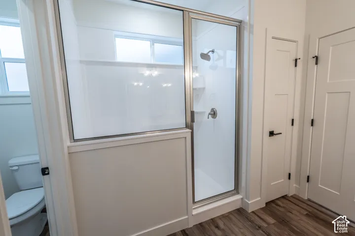 Glass-enclosed shower with a brushed nickel showerhead and control