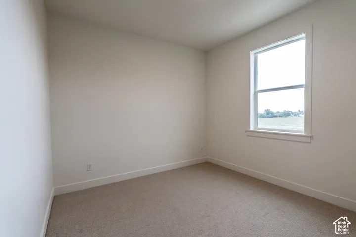 Neutral tone wall paint, light-colored carpeting, and a single-pane window