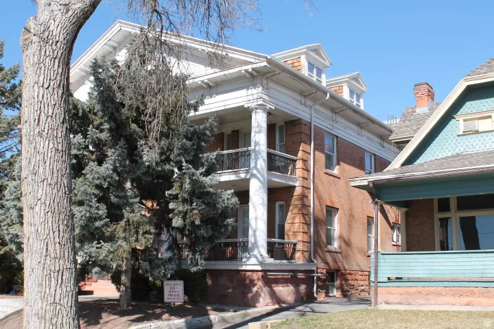 Brick exterior featuring a two-story columned portico and decorative balustrades