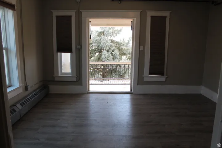 Room featuring wood-finish flooring, neutral wall paint, and white trim