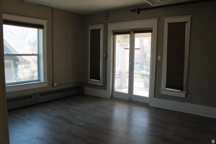 Room featuring wood-finish flooring, neutral wall tones, and white trim